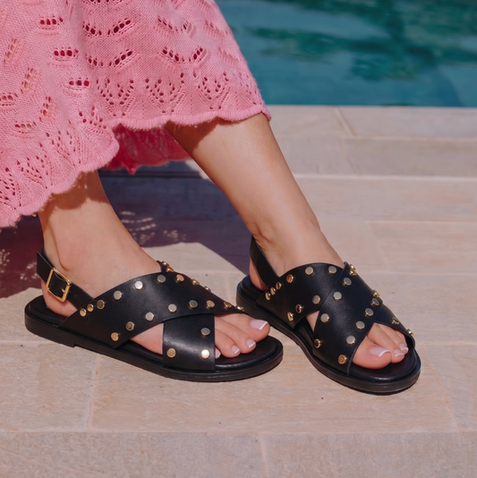 Sandalo flat in nappa nera con fasce incrociate borchiate